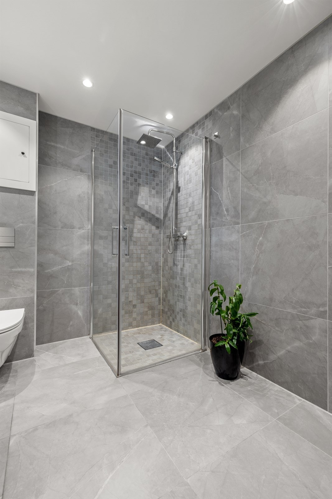 Praktisk dusjhjørne med innfellbare glassdører og behagelige varmekabler i gulvet. Galleribilde