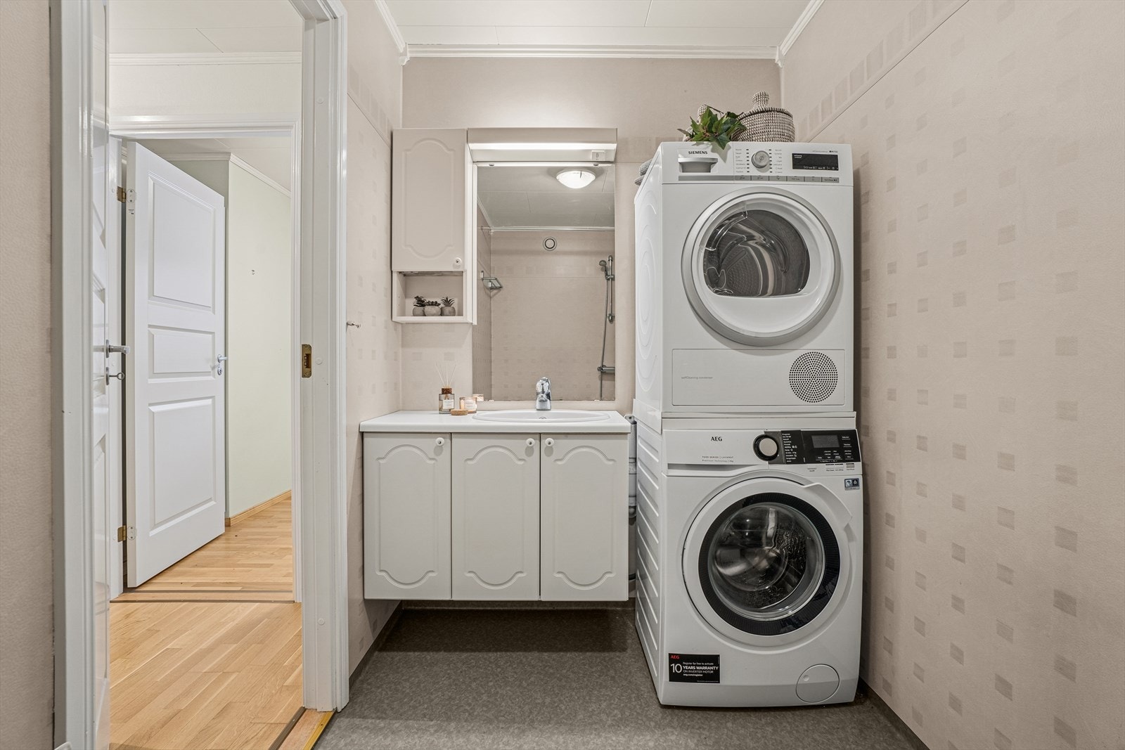 Baderom fra byggeåret 2006 med overflater bestående av våtromstapet/belegg på veggene og vinylbelegg på gulvet. Her er det opplegg for vaskemaskin. Galleribilde