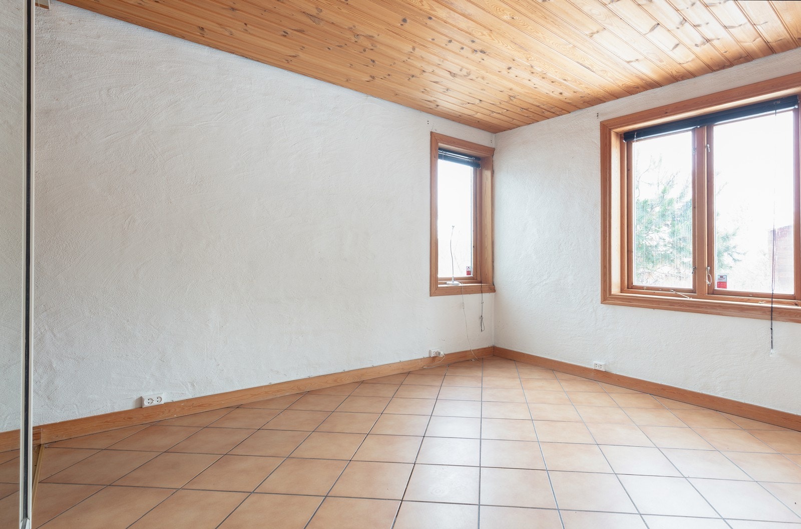 Malte flater på veggene og trepanel i taket gir rommet et lunt preg. Galleribilde