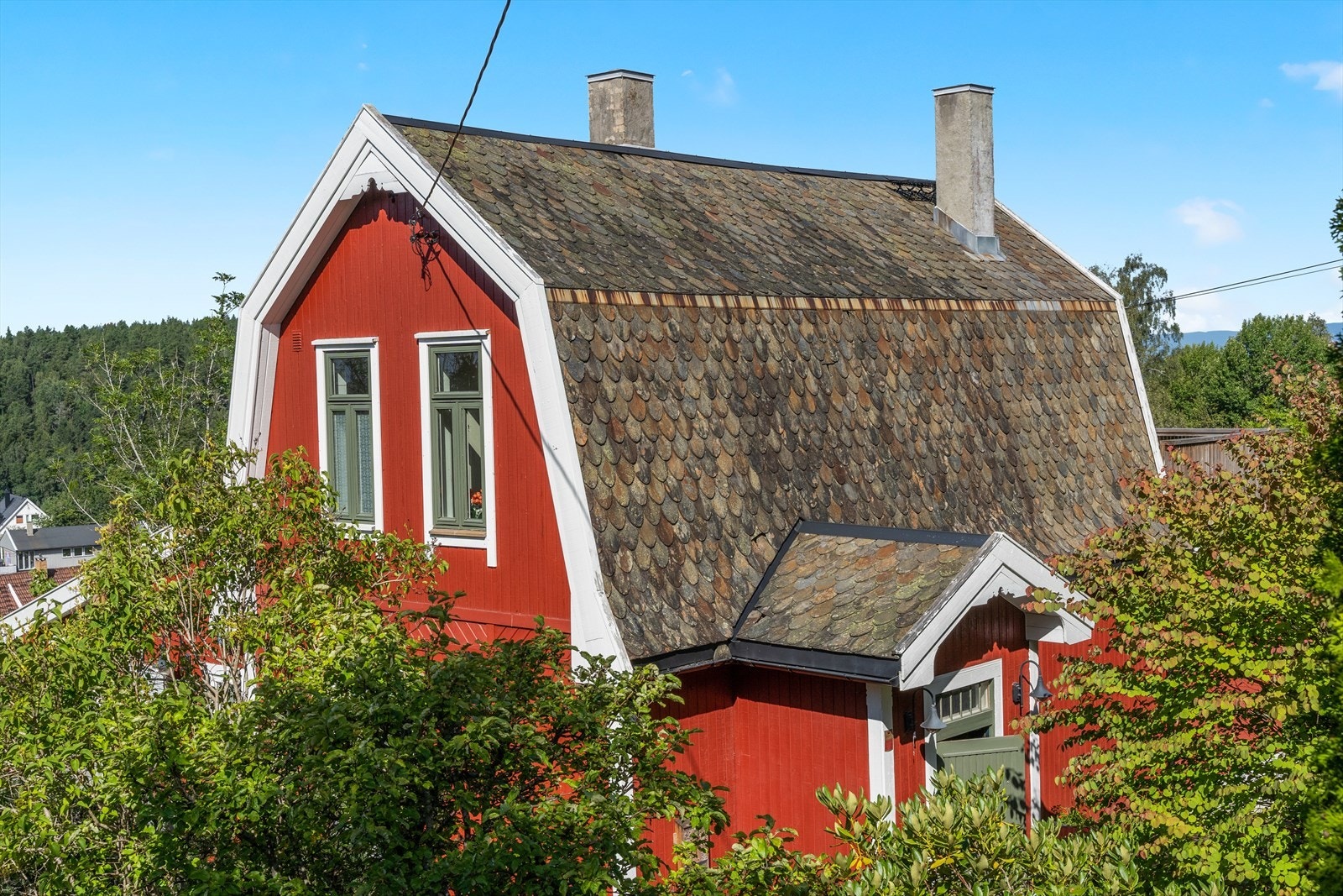 Boligen har en tømmerkonstruksjon og fasade med stående bordkledning. Galleribilde