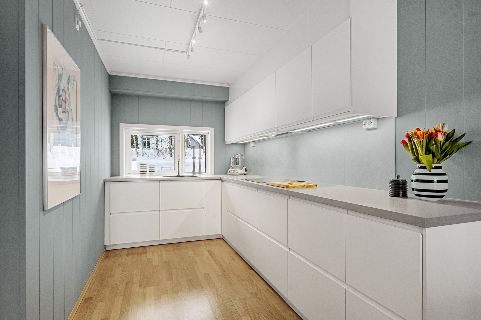 Kjøkkenet har moderne innredning med glatte fronter, laminat benkeplate og integrerte hvitevarer. Galleribilde