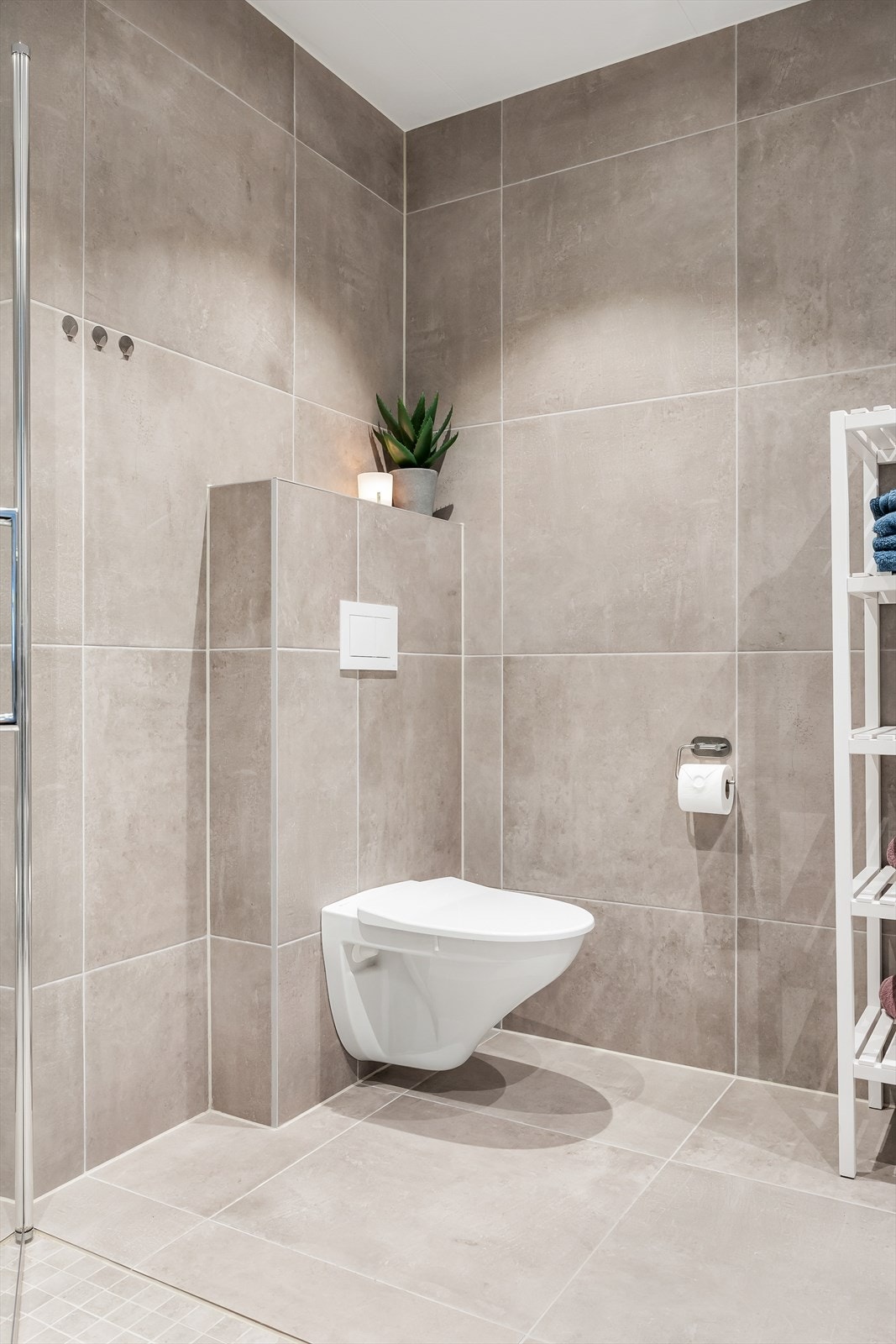 Toalettet er vegghengt og det er dusjhjørne med innfellbare glassdører. Galleribilde