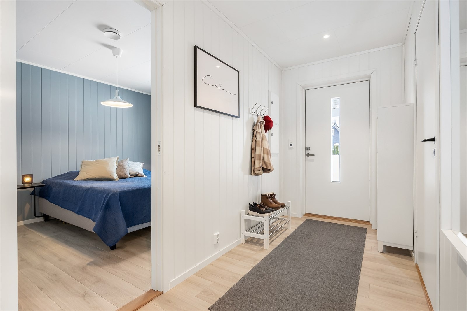 Entréen er lys og innbydende med panelplater på veggene og gulv med 1-stavs laminat. Galleribilde