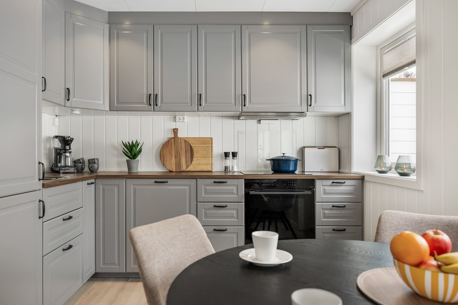 Innredningen har grå, profilerte fronter og laminatbenkeplate med dobbel oppvaskkum. Galleribilde