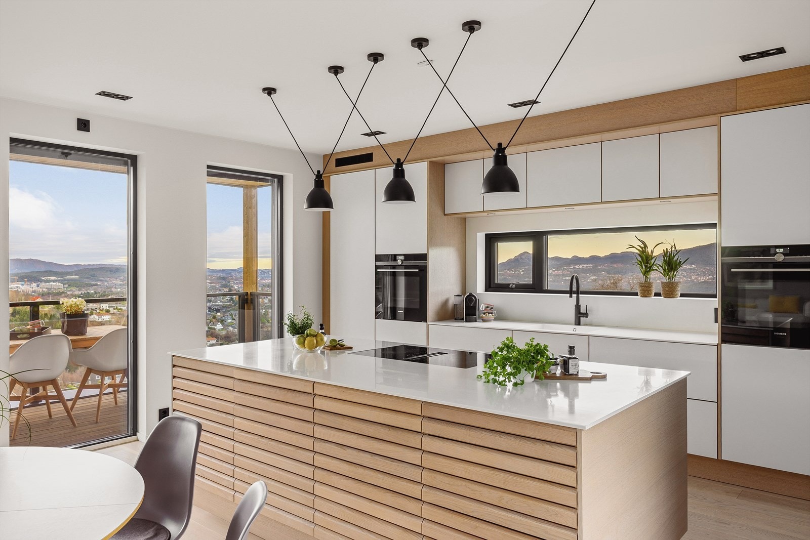 Moderne kjøkken fra HTH innredet med slette fronter og eikelamell fronter på øy. Galleribilde