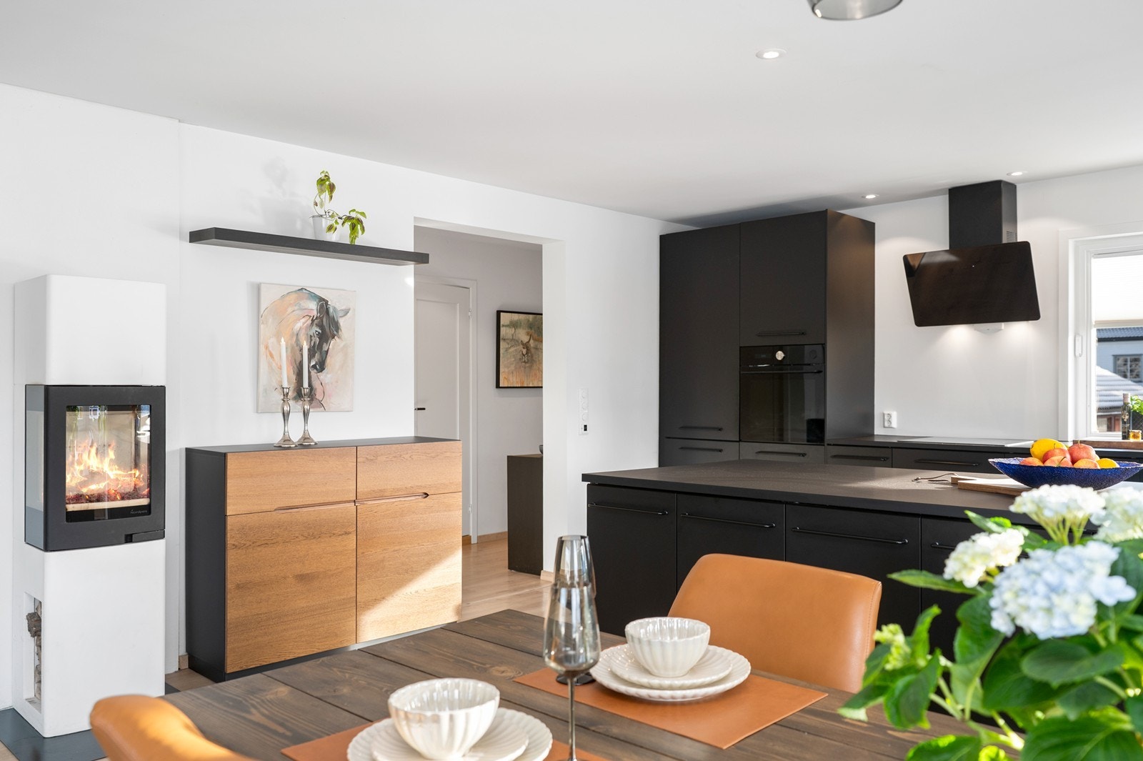 En peisovn med glassfelt gir lun varme til oppholdsrommet. Galleribilde