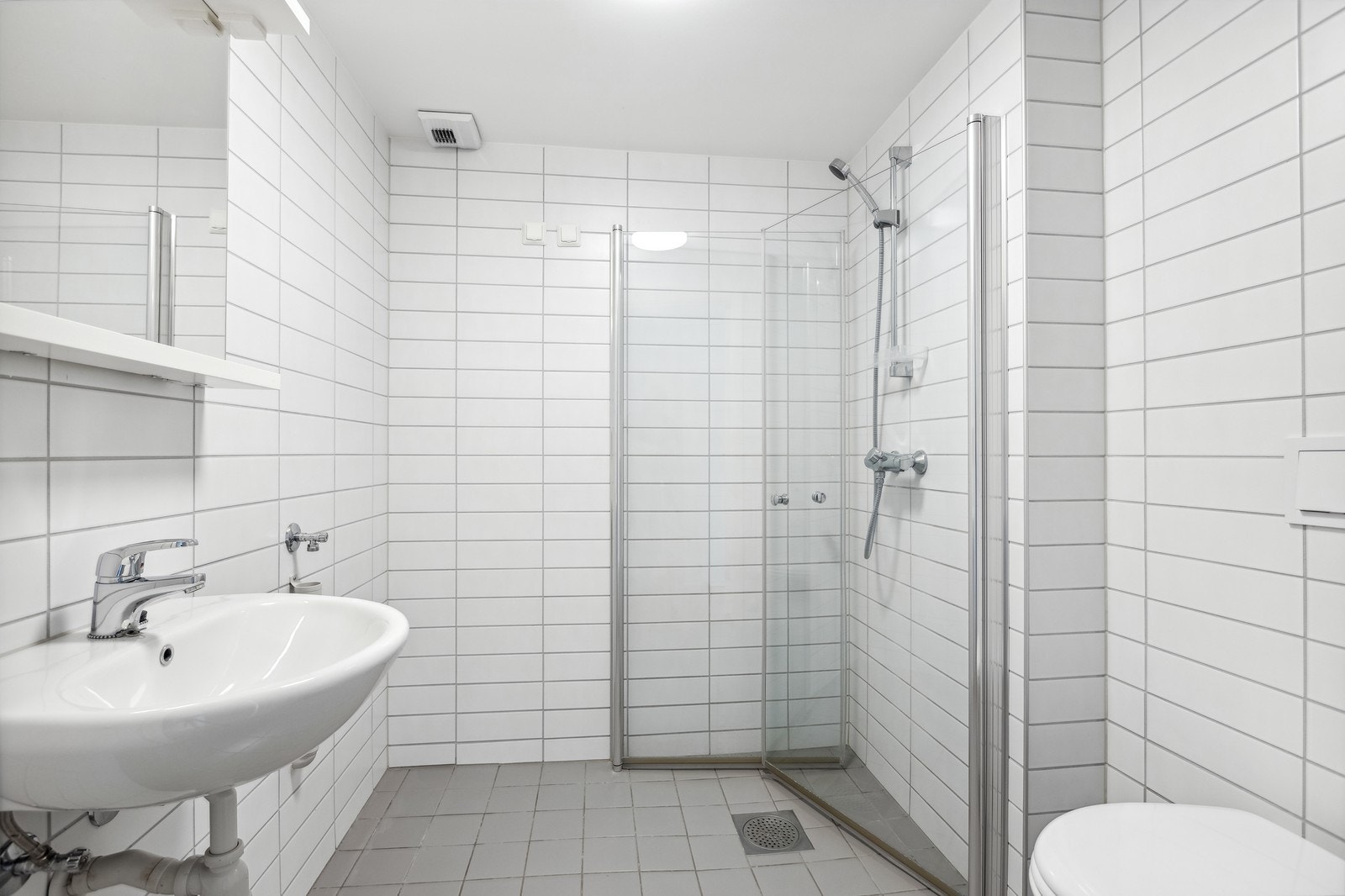 Flislagt bad med varmekabler og opplegg for vaskemaskin. Galleribilde