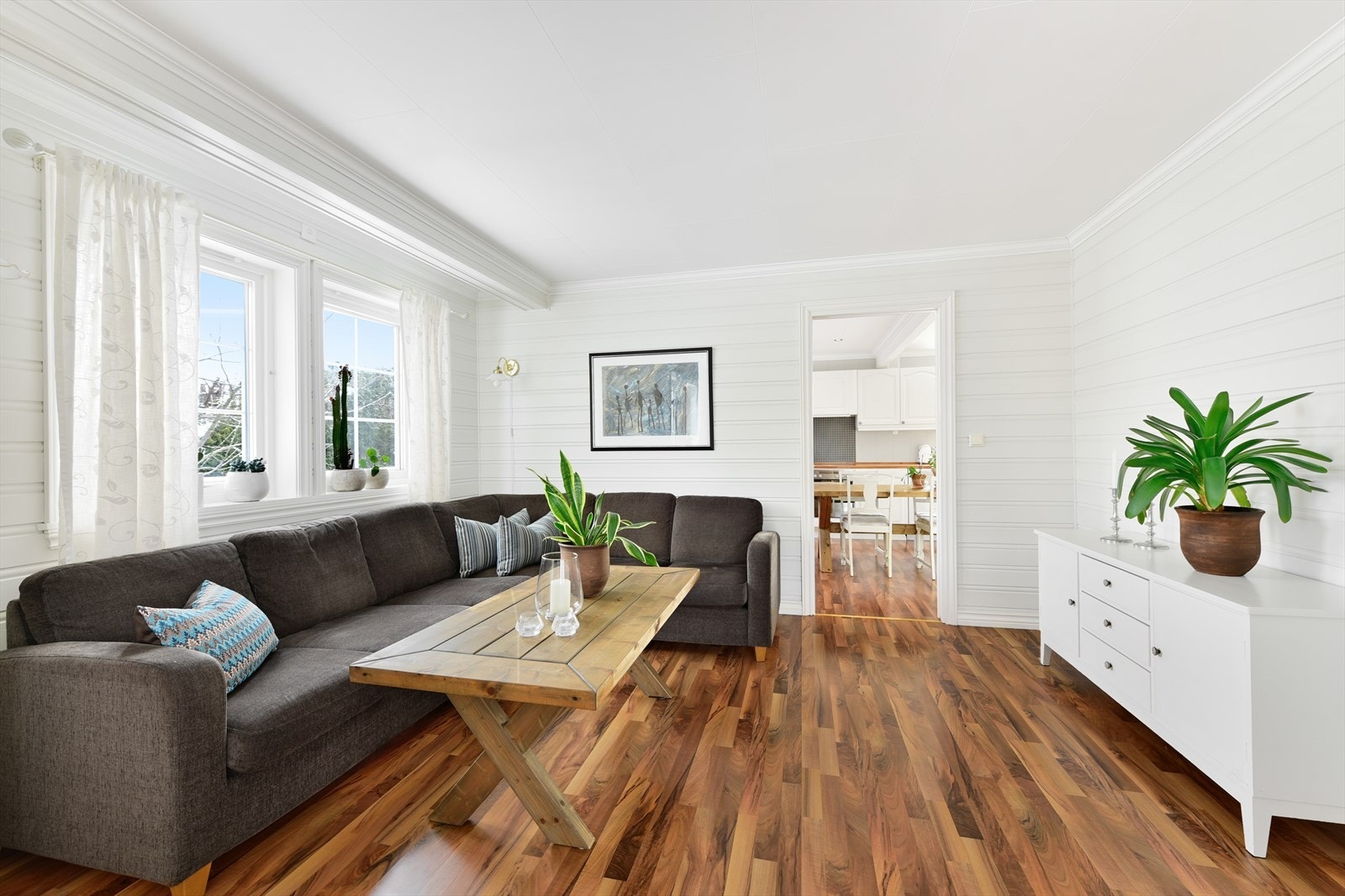 Stuen går i vinkel, noe som gir fleksible møbleringsmuligheter for både sofagruppe og spisebord. Galleribilde