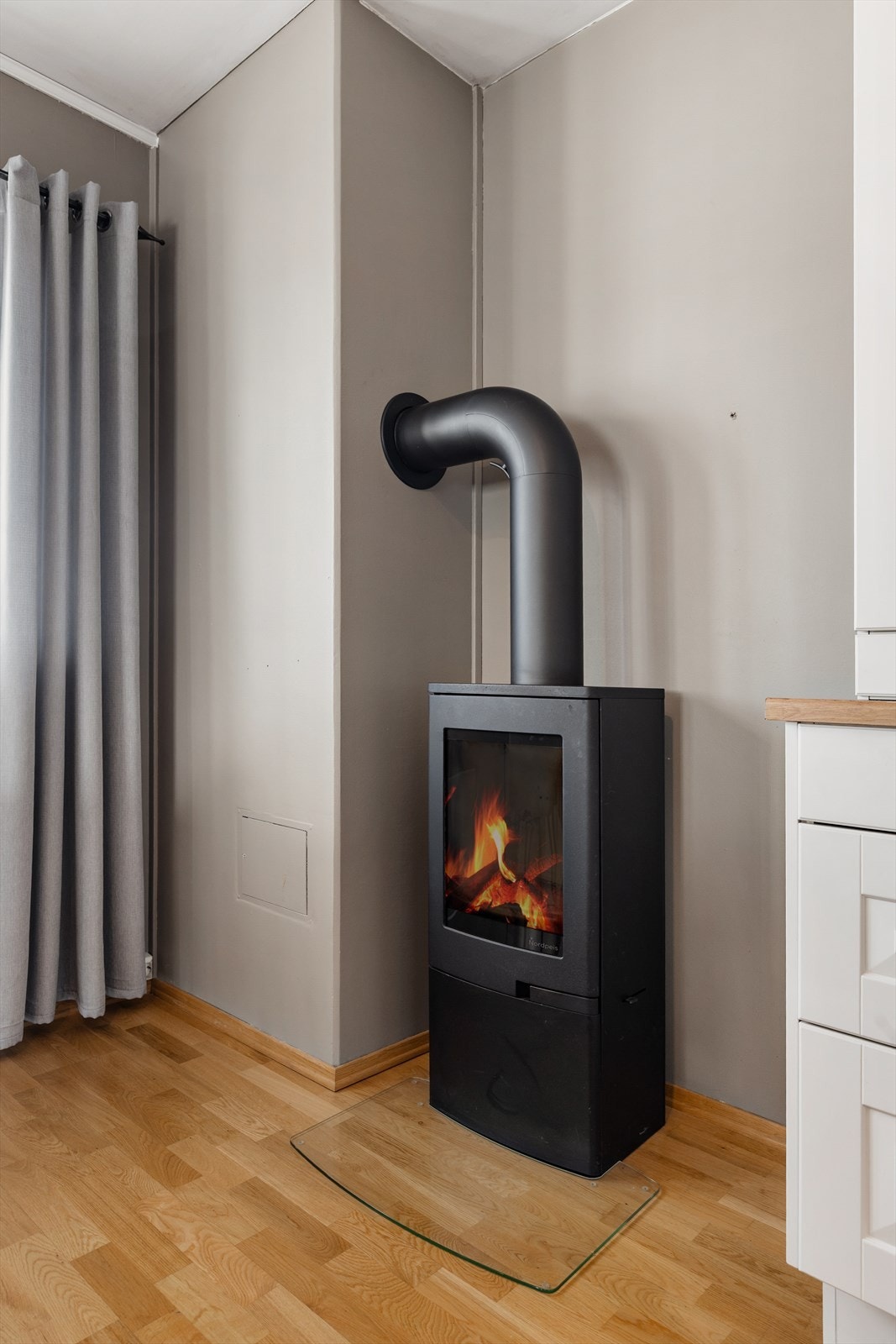Ildsted plassert på kjøkkenet sikrer optimal oppvarming i rommet. Galleribilde