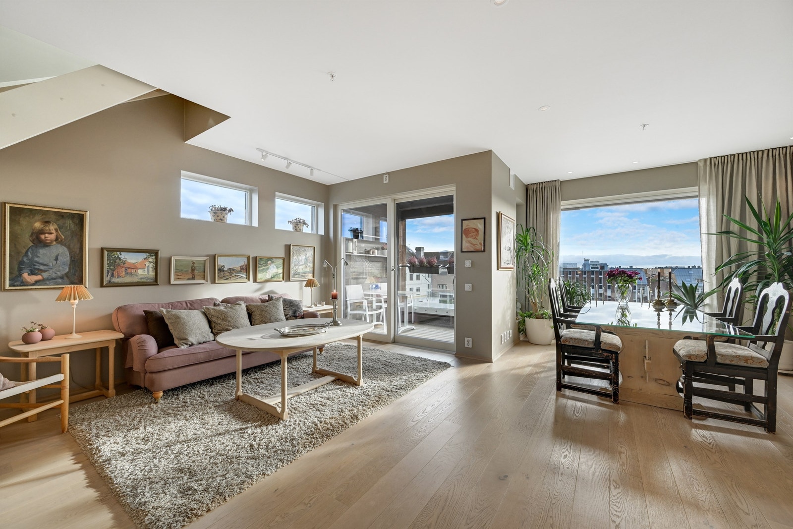 Stor stue med åpen kjøkkenløsning, spiseplass og utgang balkong. Galleribilde