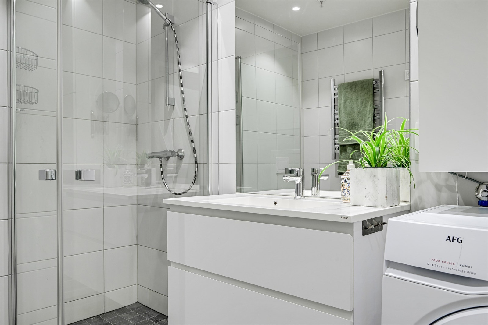 Badet er romslig med dusj og wc samt en nisje med opplegg til vaskemaskin og tørketrommel. Galleribilde