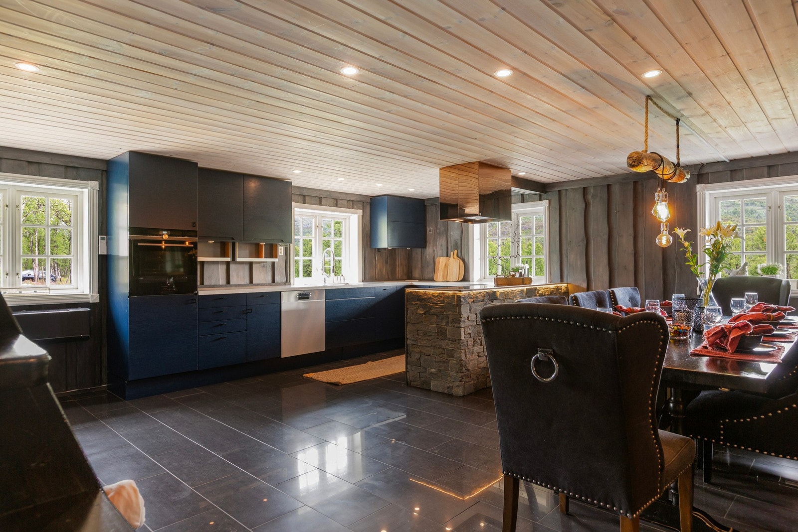 Moderne kjøkkeninnredning med glatte fronter og benkeplate av flis med god plass til matlaging. Galleribilde