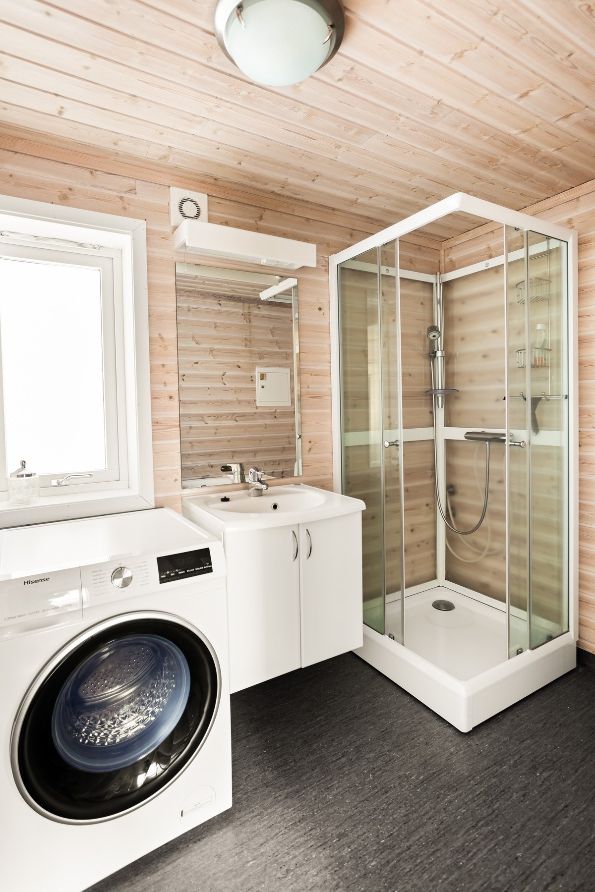 Badet er utstyrt med dusjhjørne, toalett, opplegg til vaskemaskin og servant m/innredning. Galleribilde