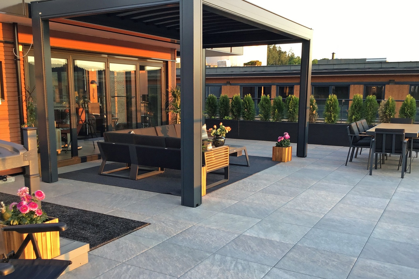 Fra stuen leder foldedører direkte ut til terrassen, som er anlagt i flukt med gulvnivå og tilnærmet lik stuegulvet. Dette gir en sømløs overgang mellom inne og ute. Galleribilde