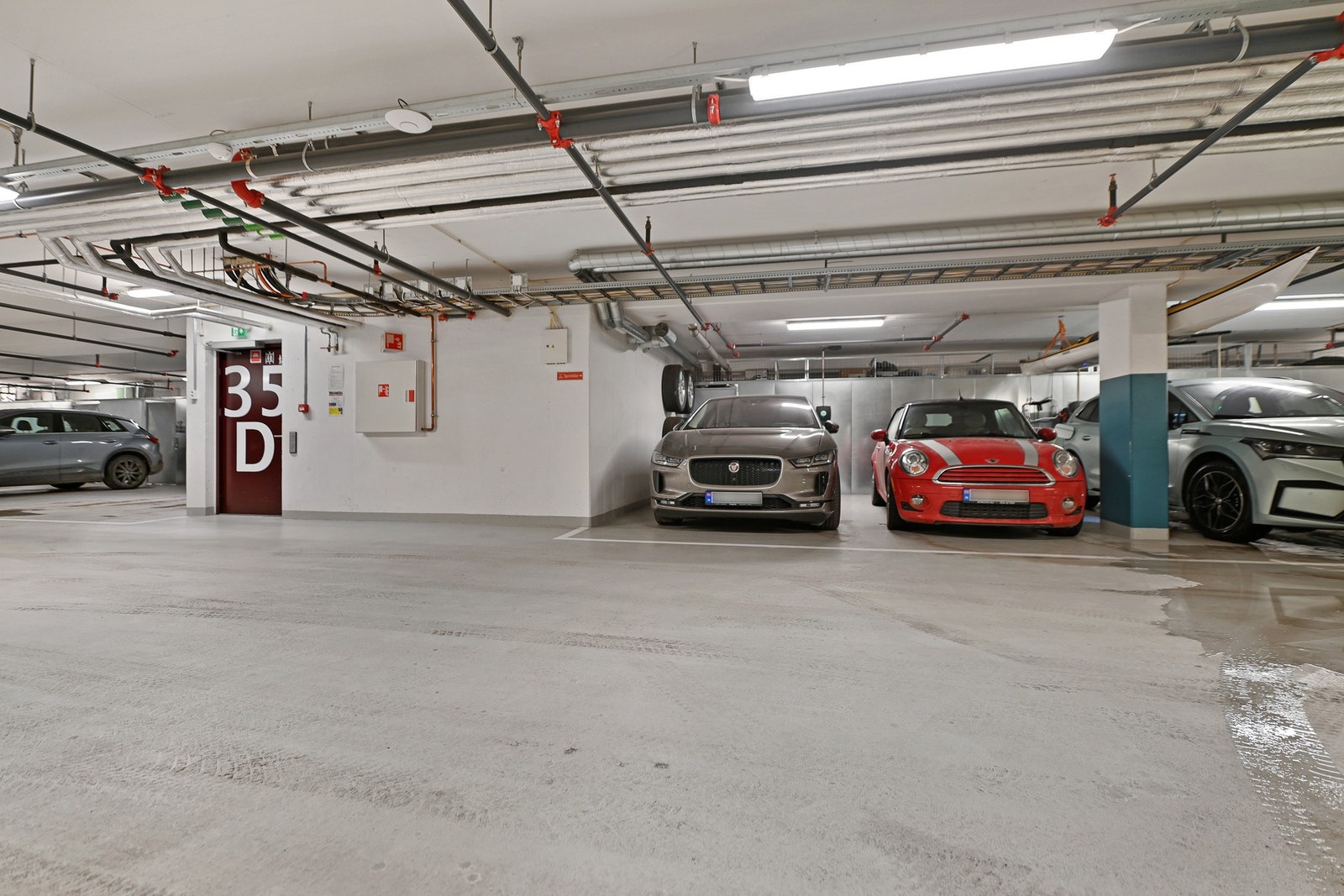 Seksjonen eier én stor plass med kapasitet til to biler i felles garasjekjeller. Det er monter El-billader. Galleribilde