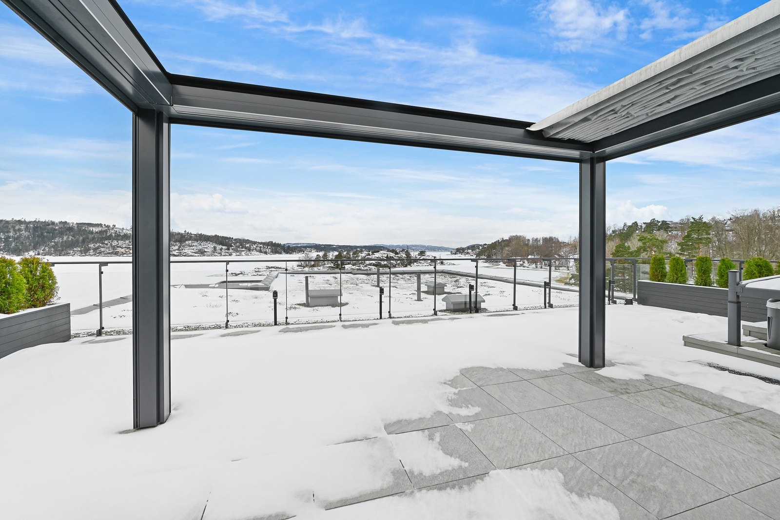 I sommerhalvåret benyttes uteplassen aktivt, og terrassen er derfor møblert med flere sittegrupper i en tidløs og klassisk stil. Videre er uteplassen utstyrt med stilrene glassvegger som gir effektiv vindskjerming, samtidig som den åpne følelsen og den fr Galleribilde