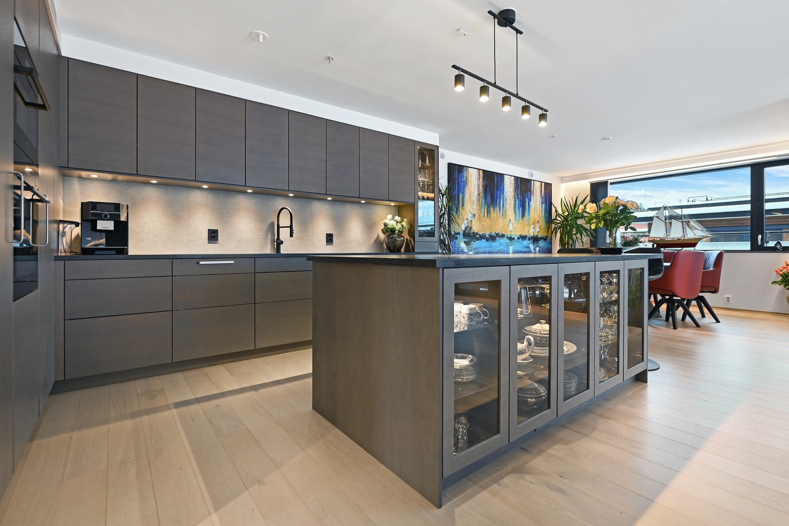 Mot stuen har de valgt å ha en stor, kjøkkenøy. Her tilberedes enkle retter og store festmåltider og her serveres gjestene. En svært praktisk løsning når flere skal lage mat sammen også er det flott med den ekstra oppbevaringsplassen. Galleribilde