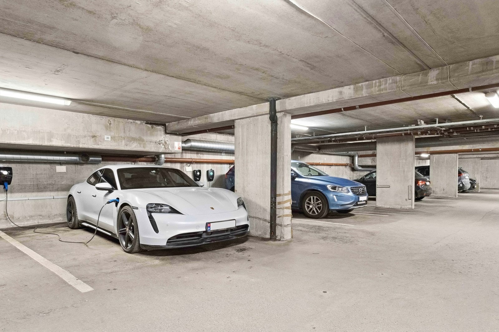 Fast romslig parkeringsplass (nr. 35) i garasjekjeller med el-bil lader, samt egen privat bod i kjeller Galleribilde