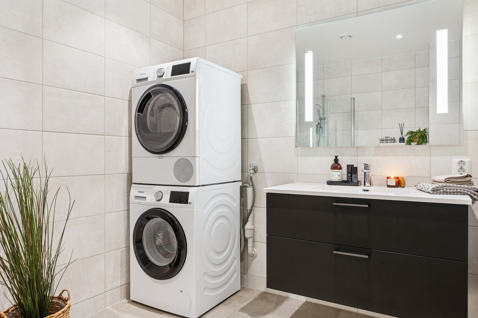 Her er det også opplegg og plass for både vaskemaskin og tørketrommel. Lekkert speil med innfelte lysdetaljer over servantskapet. Galleribilde