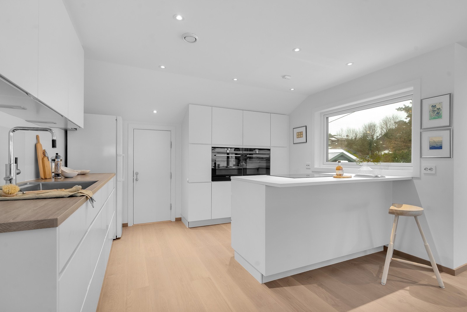 Praktisk kjøkken med mye skap-og benkepass. Dør inn til romslig lagringsloft Galleribilde