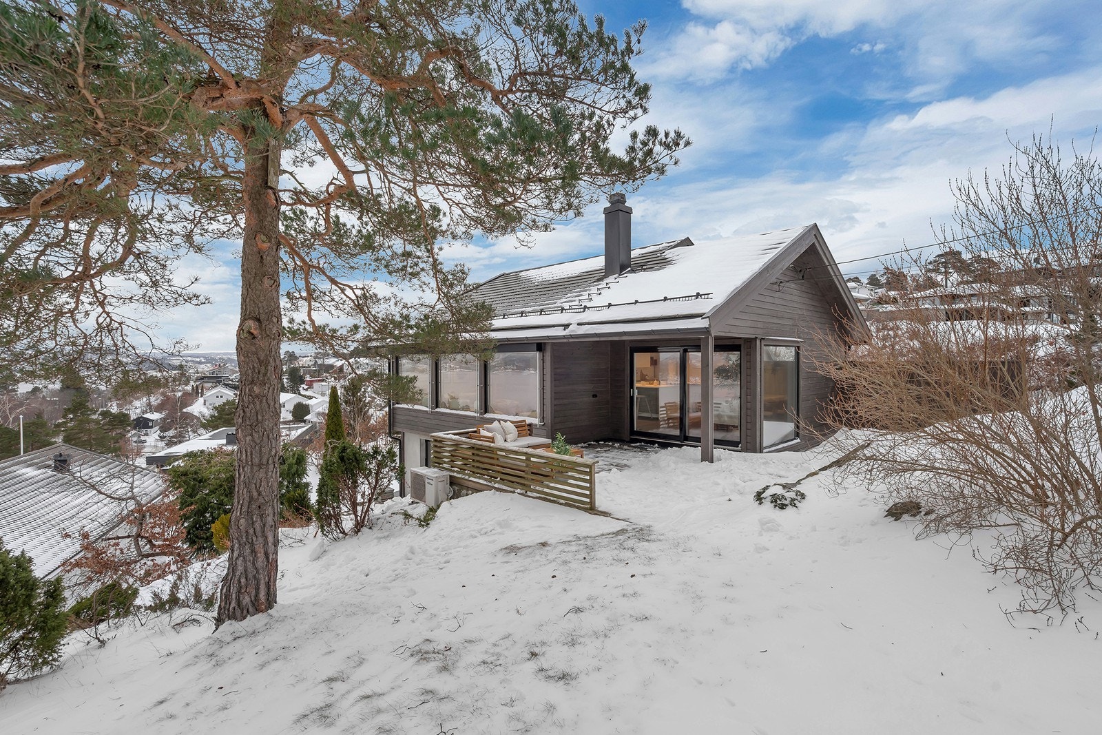 Stor tomt opparbeidet med plen, platting og noe naturtomt Galleribilde