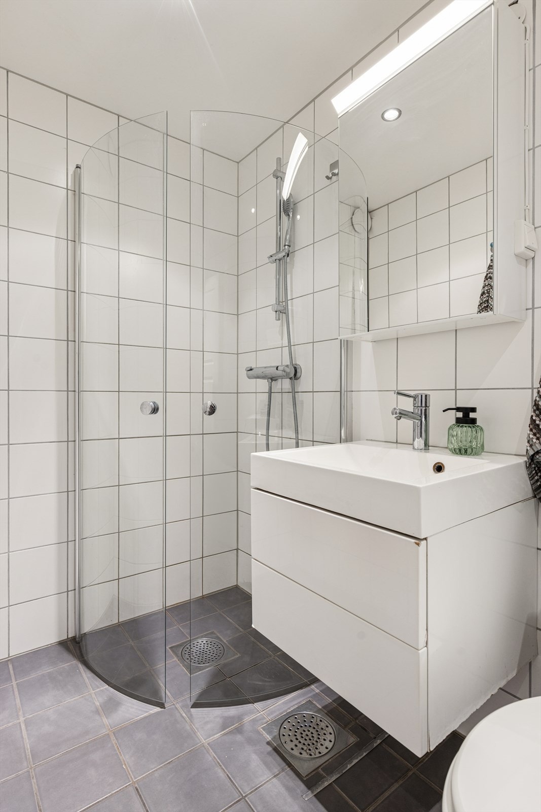 Lyst og delikat bad med fliser på gulv og vegger Galleribilde