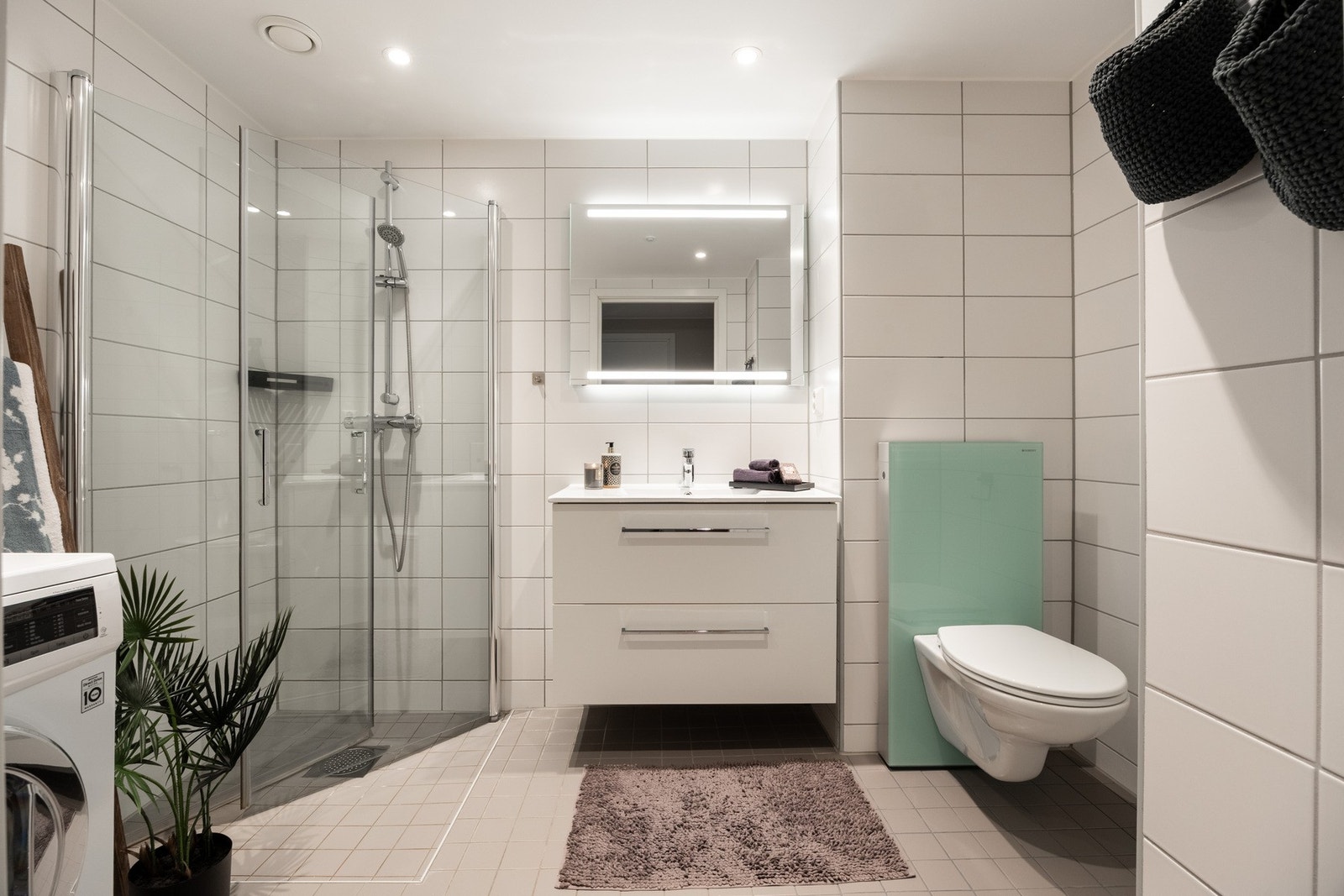 Lyst og pent baderom fra 2020. Opplegg for vaskemaskin. Galleribilde