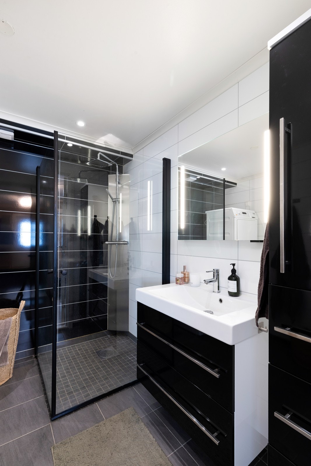 Fliser på gulv, vegghengt servantmøbel og dusjhjørne i glass. Galleribilde