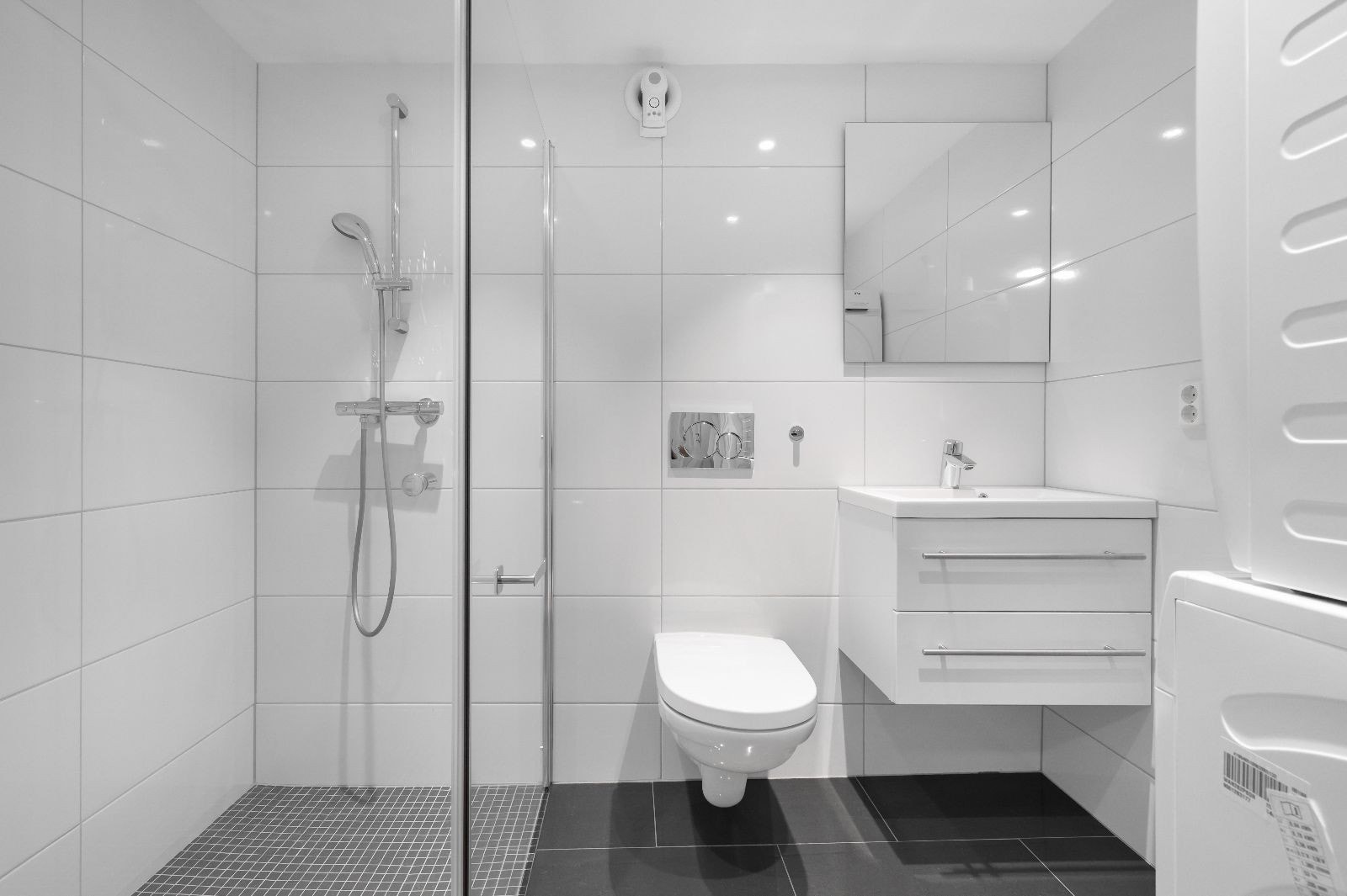 Lekkert bad med dusjhjørne, wc, servant og vaskemaskin/tørketrommel Galleribilde