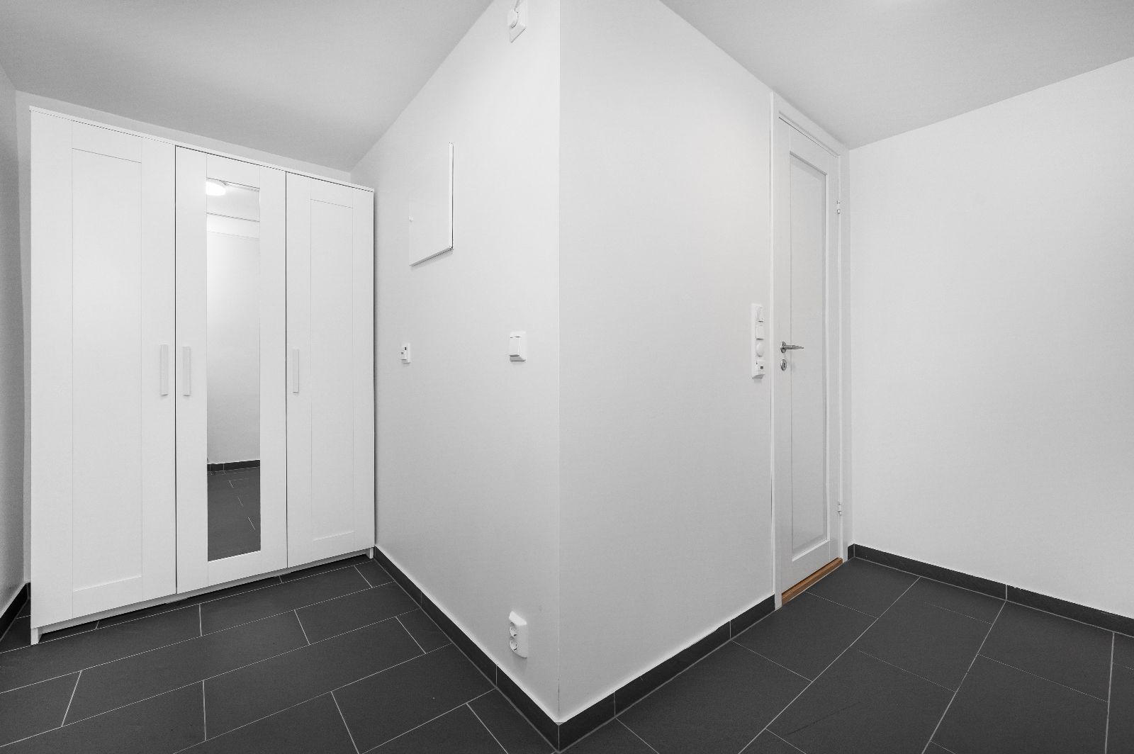 Romslig entre med garderobeskap og inngang til bad Galleribilde