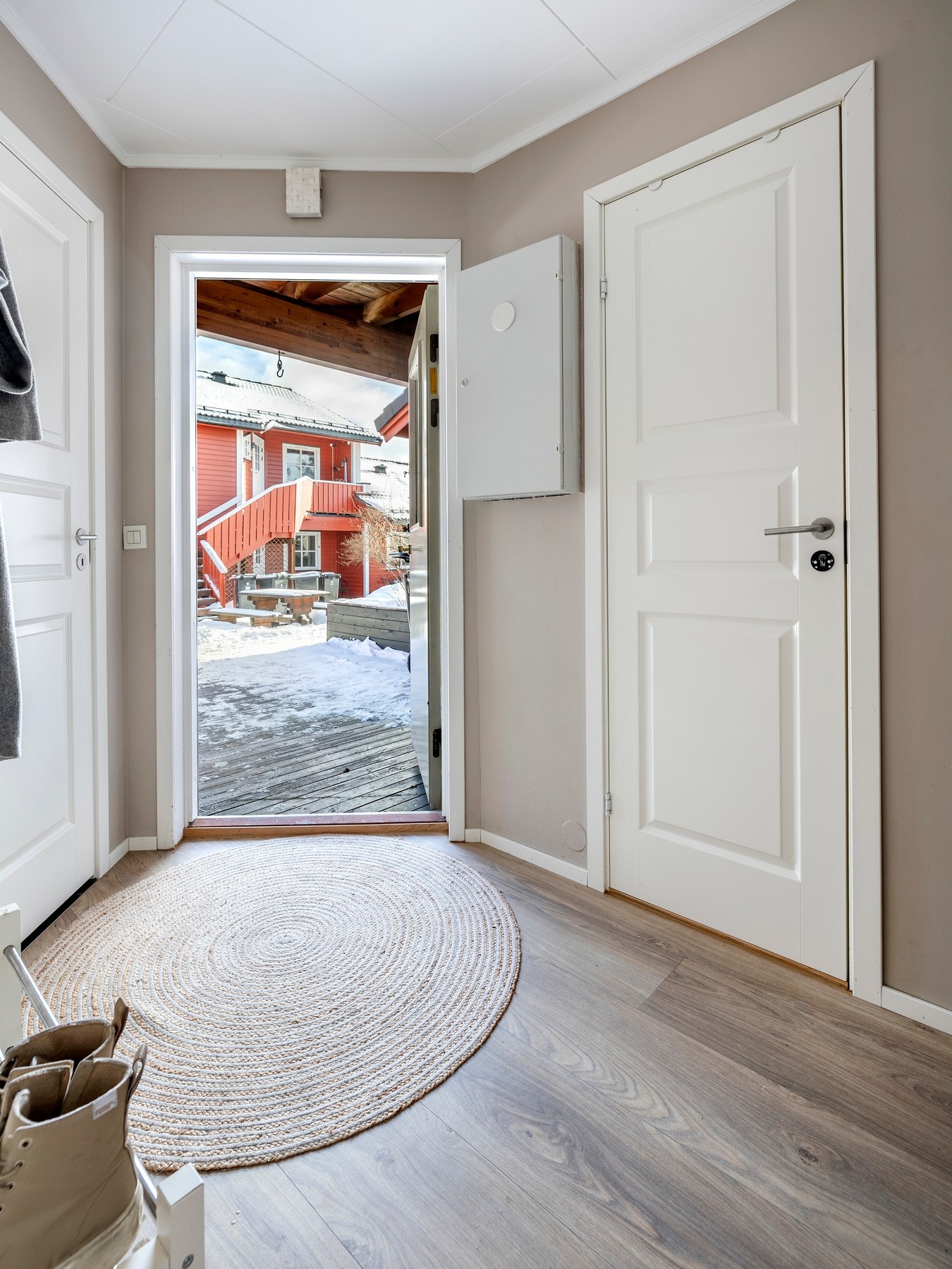 Entre med malte vegger i moderne fargetoner og laminatgulv. Entréen er innredet med et praktisk garderobeskap. Galleribilde