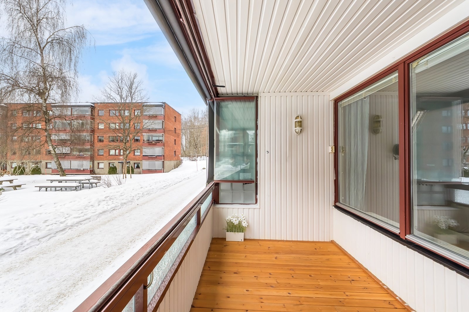 Balkongen har trepanel på gulvet og vender ut mot borettslagets rolige fellesområder. Galleribilde