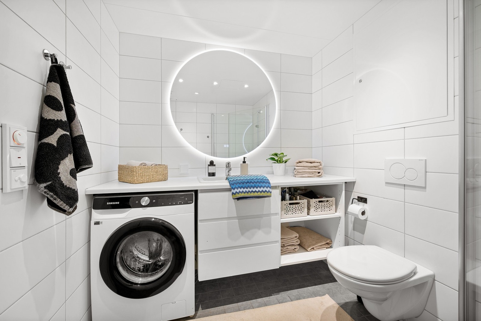 Delikat flislagt baderom med elektriske varmekabler i gulv, spotter i himling og moderne lysspeil. Galleribilde