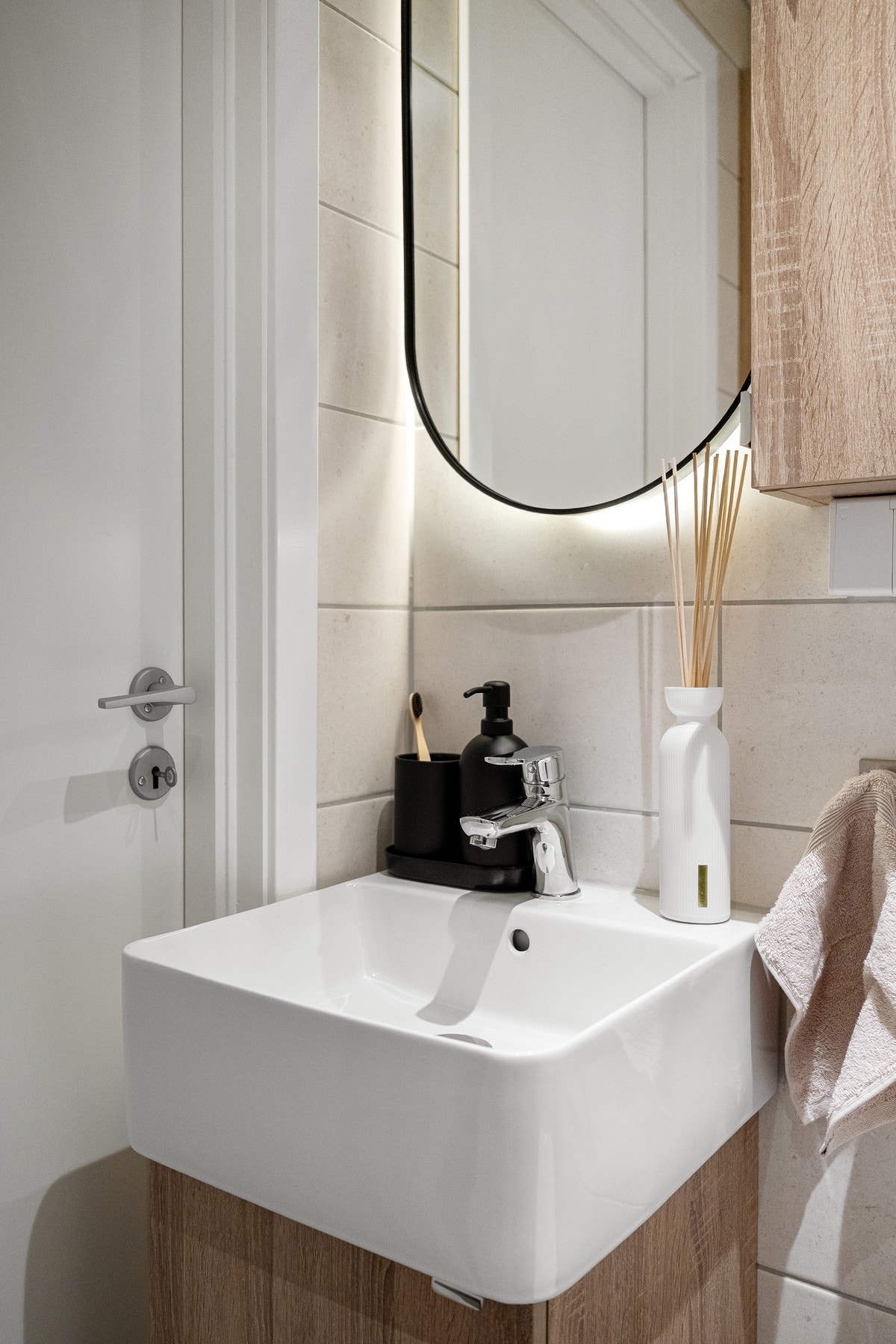 Badet er innredet med servant og underskap, veggspeil med integrert belysning, vegghengt skap og vegghengt WC, noe som gjør rengjøringen enkel og praktisk. Galleribilde