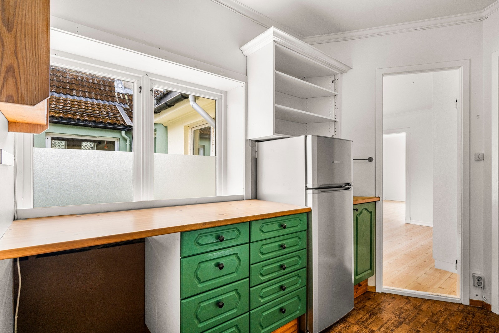 Kjøkkeninnredningen består av profilerte fronter, ett overskap har glassfront, laminat benkeplate, over benkeplaten er det benyttet fliser, stål oppvaskkum og ventilator. Galleribilde