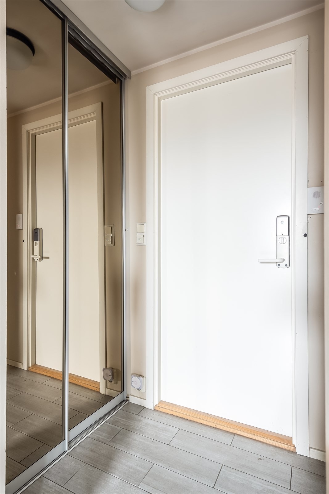 Innbydende entré på 2,5 kvm med flislagt gulv og praktisk skyvedørsgarderobe. Galleribilde