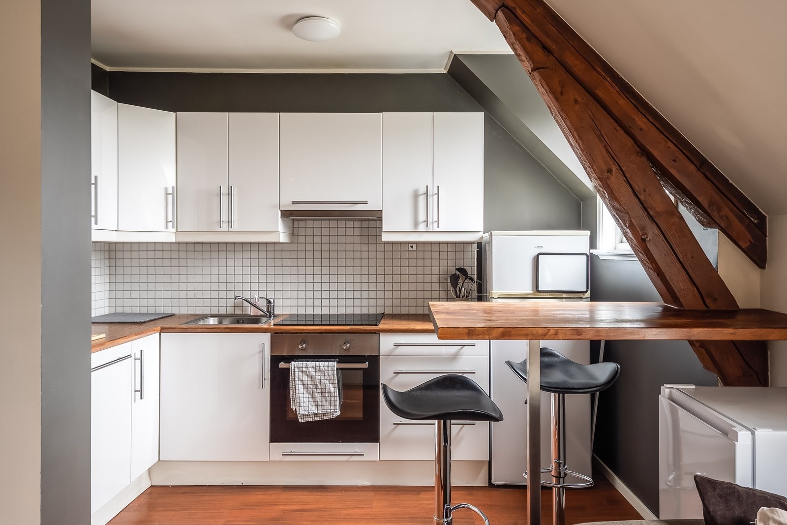 Lyst og moderne hjørnekjøkken med praktisk innredning og god skap- og benkeplass. Galleribilde