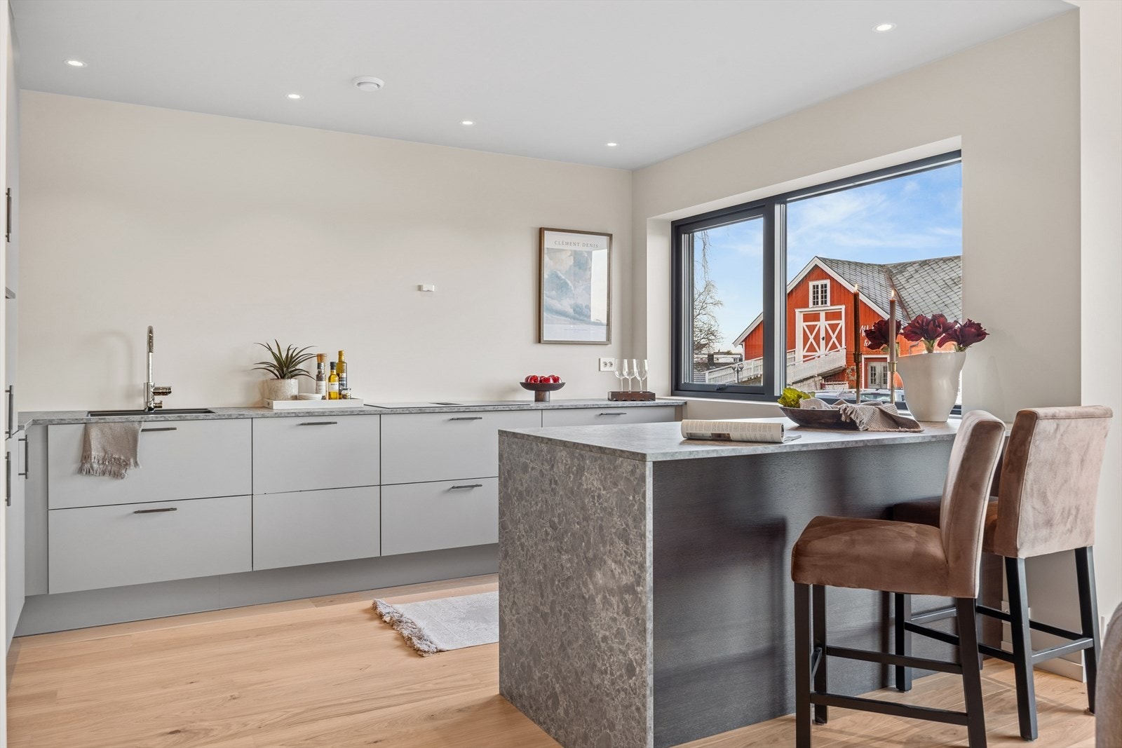 Her er det rikelig med benkeplass, godt med oppbevaring i skuffer og høyskap, samt en innbydende kjøkkenøy med sitteplasser - perfekt for sosiale sammenkomster. Galleribilde