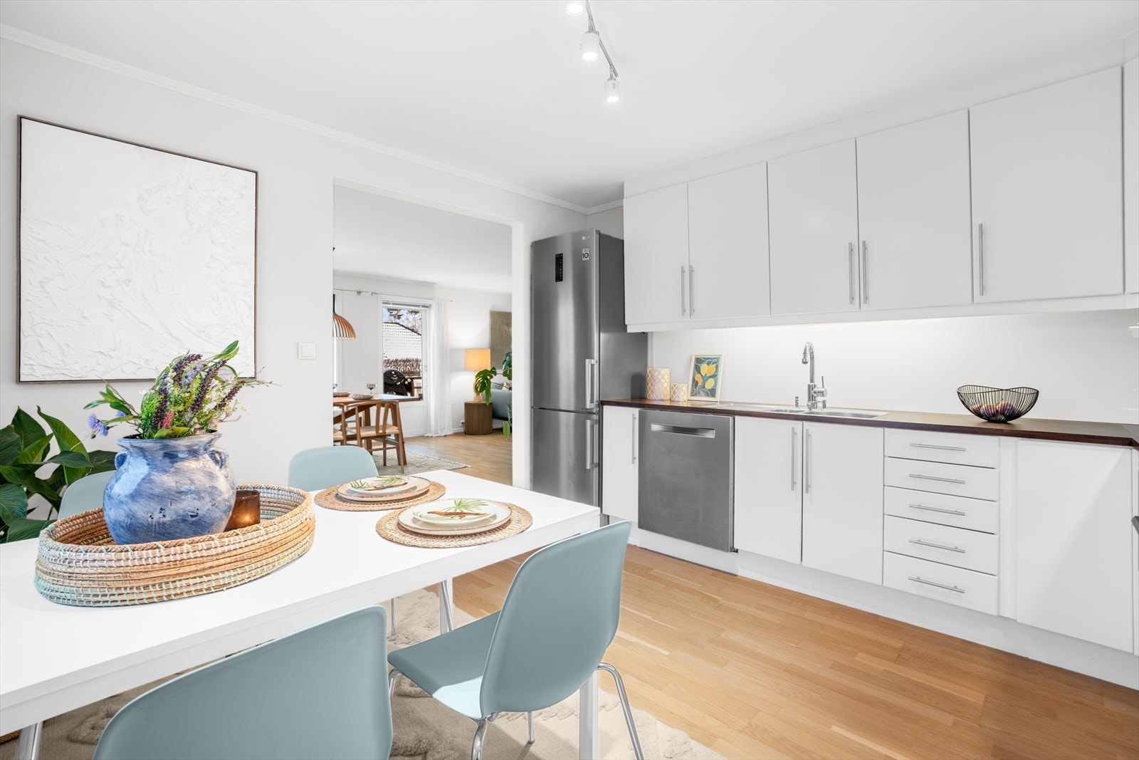 Benkeplaten i laminat er utstyrt med kjøkkenkran og en nedfelt kum i rustfritt stål. Det er belysning under overskap. Galleribilde