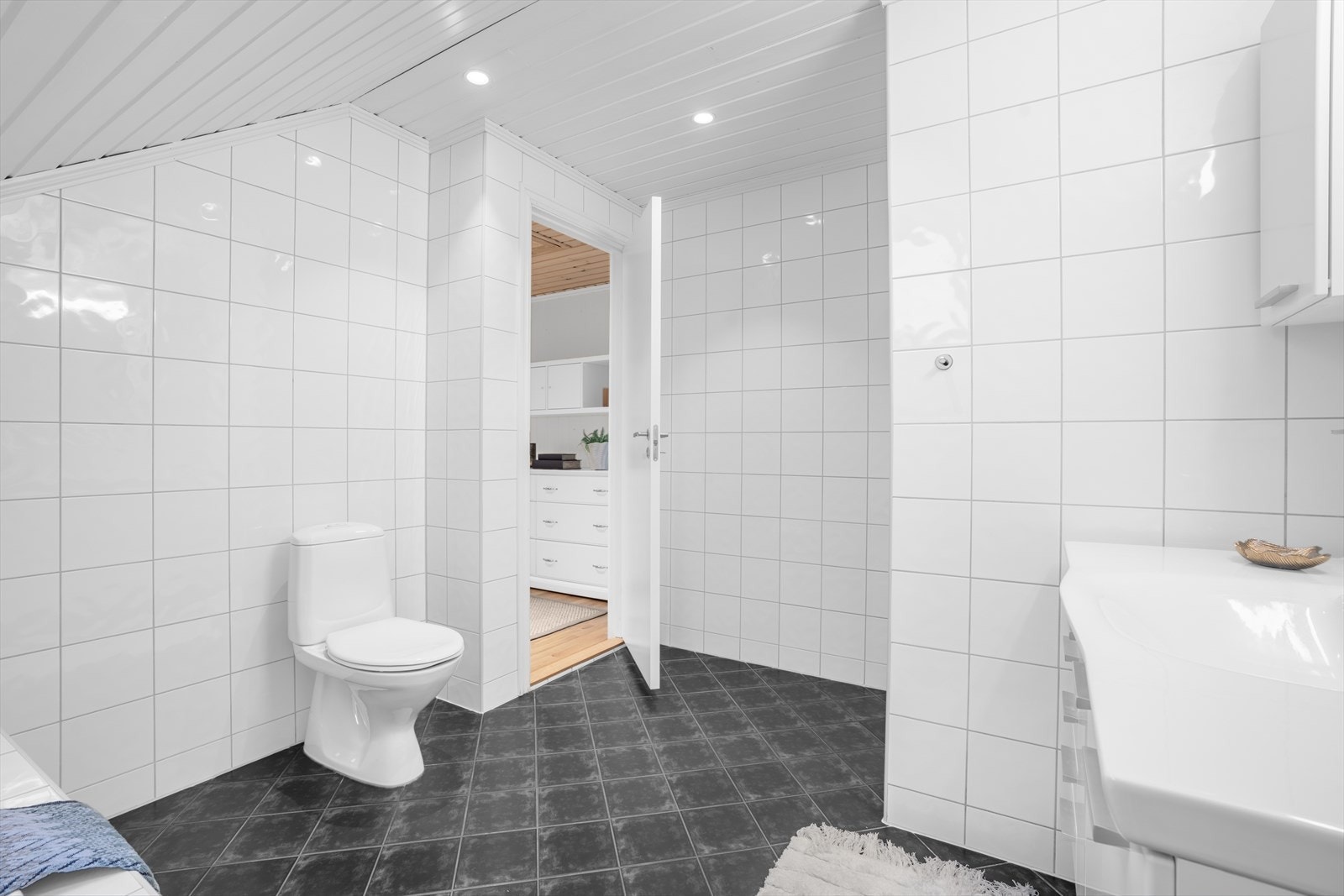 Badet har også en stor servantinnredning med praktiske skapdører under, samt speil og belysning over servanten. Galleribilde