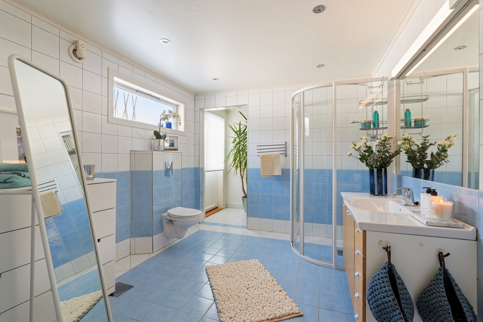 Innredningen består av en servant nedfelt i baderomsinnredning med god oppbevaringsplass, samt et veggmontert toalett som gir et moderne og lettstelt uttrykk. Dusjhjørnet har solide dusjvegger som skiller våtsonen på en praktisk og estetisk måte. Galleribilde