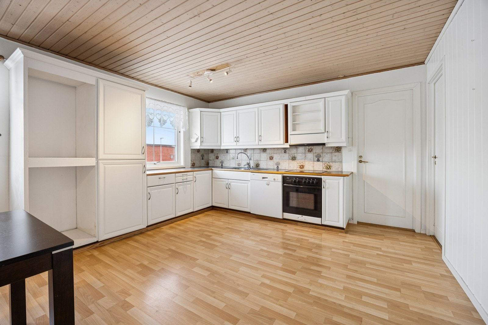 Kjøkkenet har innredning med malte, profilerte fronter og laminert benkeplate med vaskekum i stål. Galleribilde