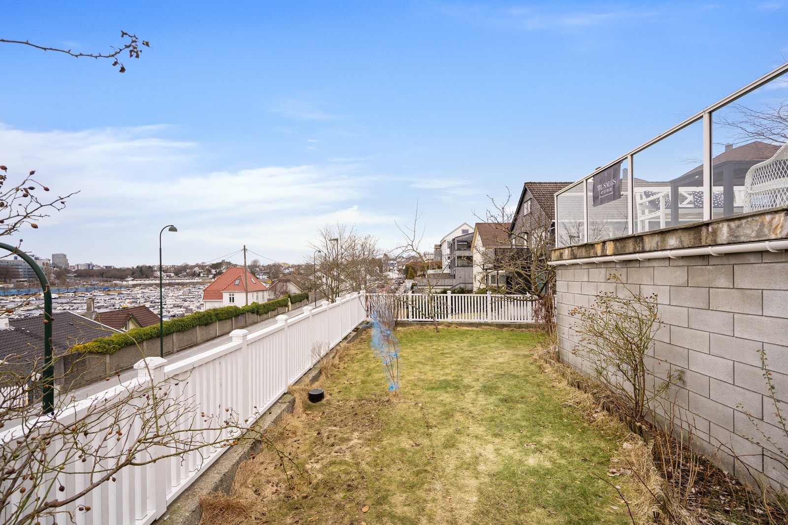 Opparbeidet uteområde med gressplen og terrasse gir en sjelden kombinasjon av utsikt, sol og hage i samme bolig. Galleribilde