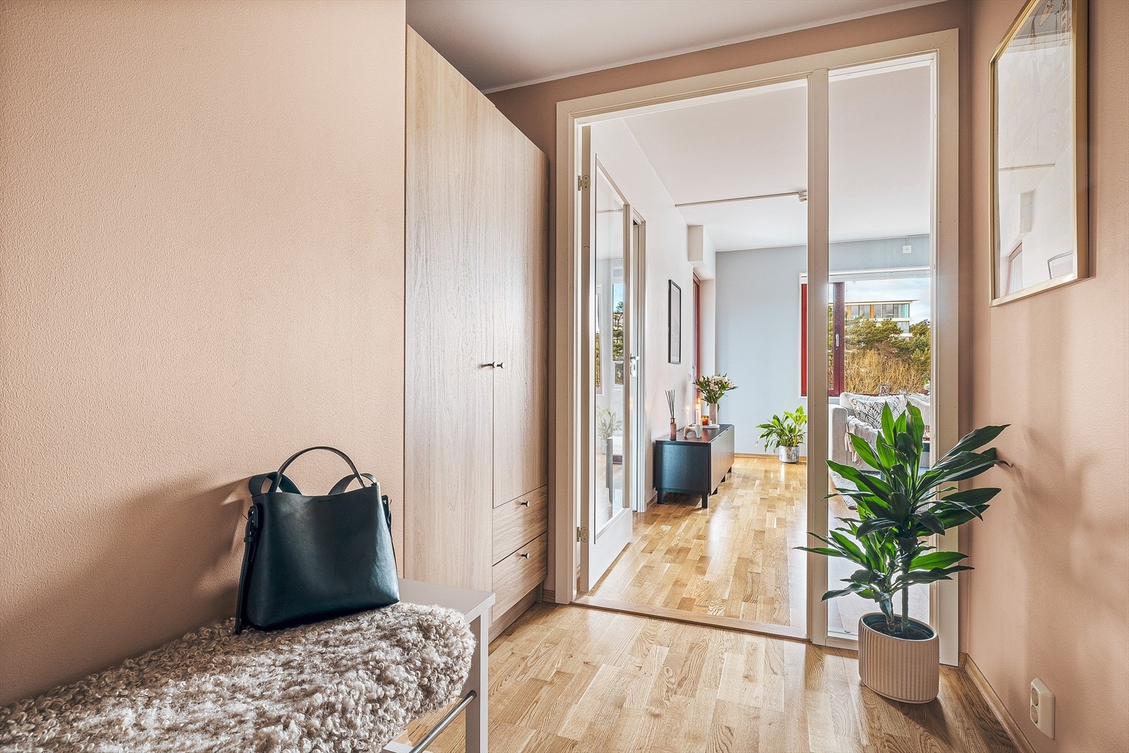 Lys entré med plass til en sittebenk og et praktisk garderobeskap. Galleribilde