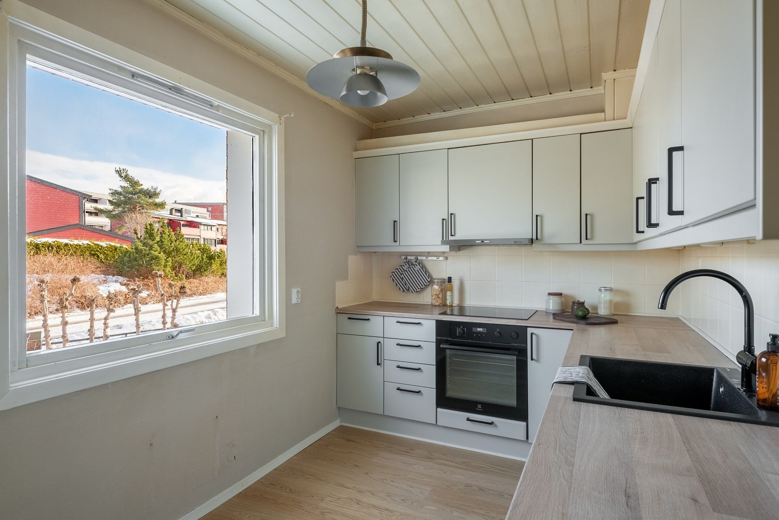 Kjøkkenet har godt med arbeidslys fra vinduet over en benkeplate med laminert overflate. Galleribilde