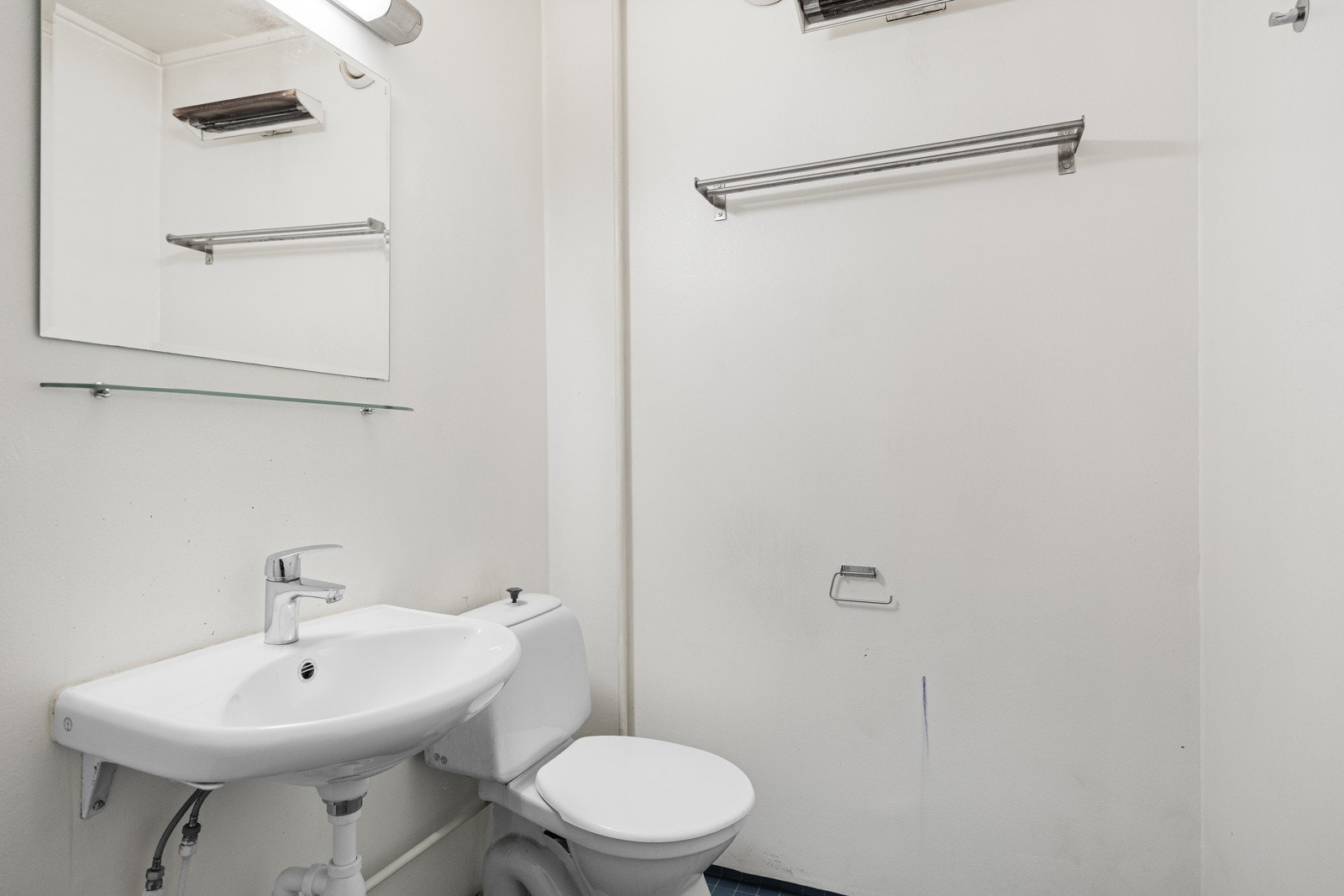 Rommet er utstyrt med vegghengt servant med speil og belysning over, dusjhjørne med forheng og gulvstående toalett. Galleribilde