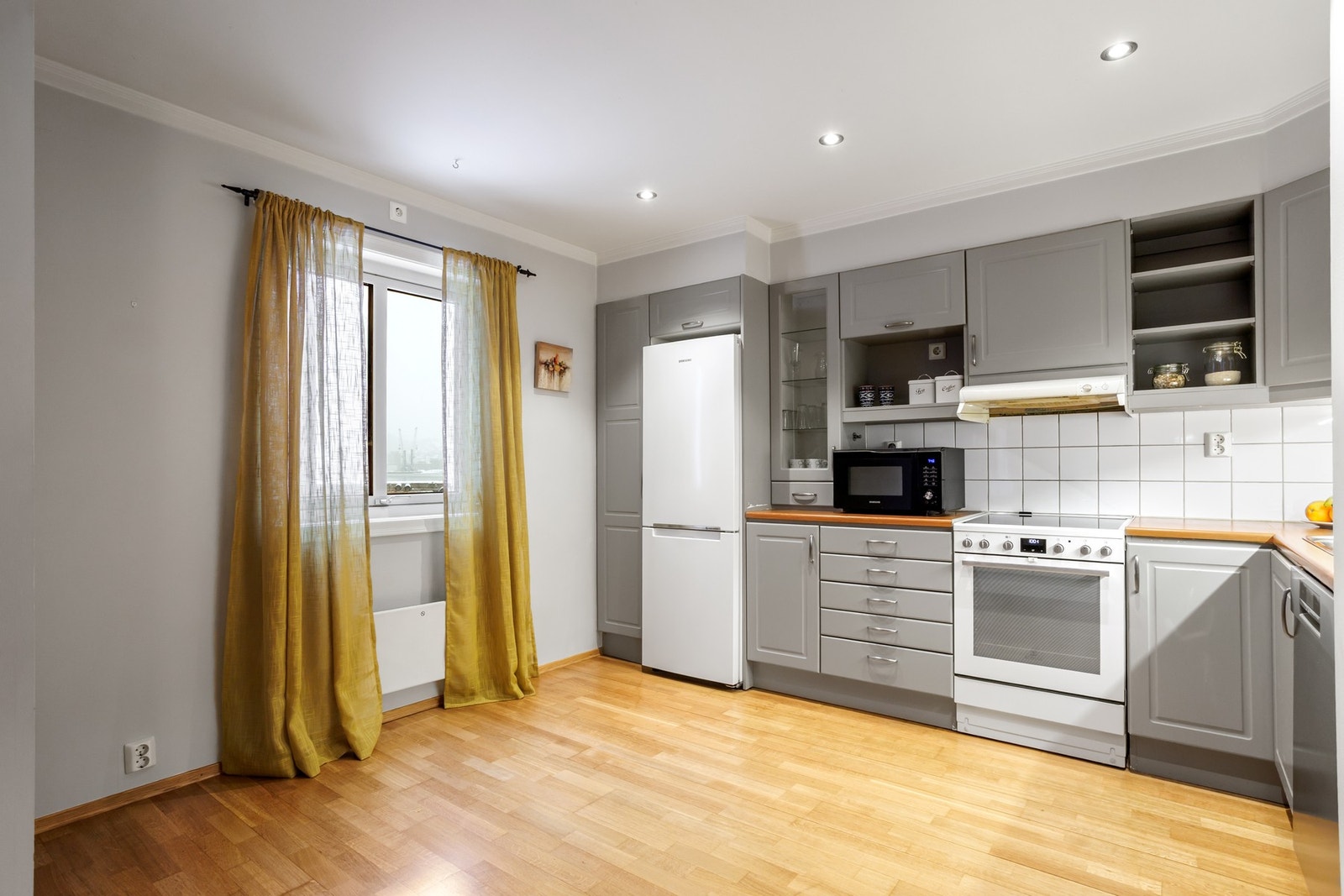 Plass til et lite bord og noen stoler foran vinduet. Galleribilde