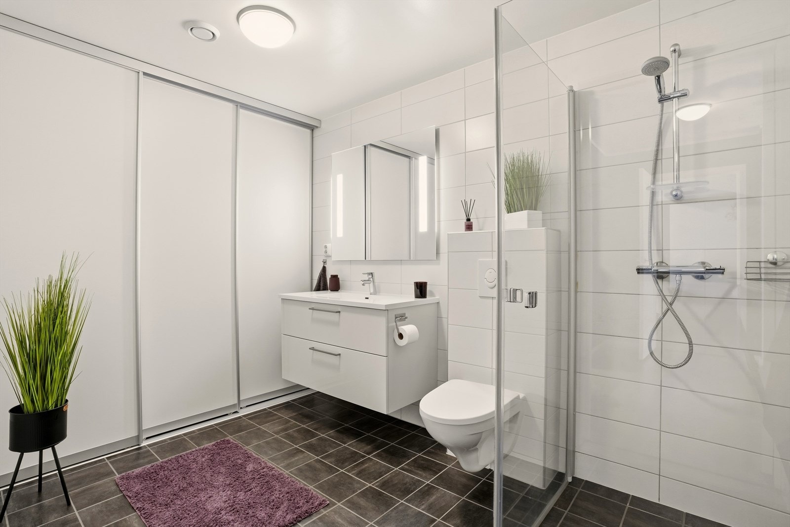 Veggene har fliser. Taket er malt. Gulvet er flislagt. Rommet har elektriske varmekabler. Galleribilde