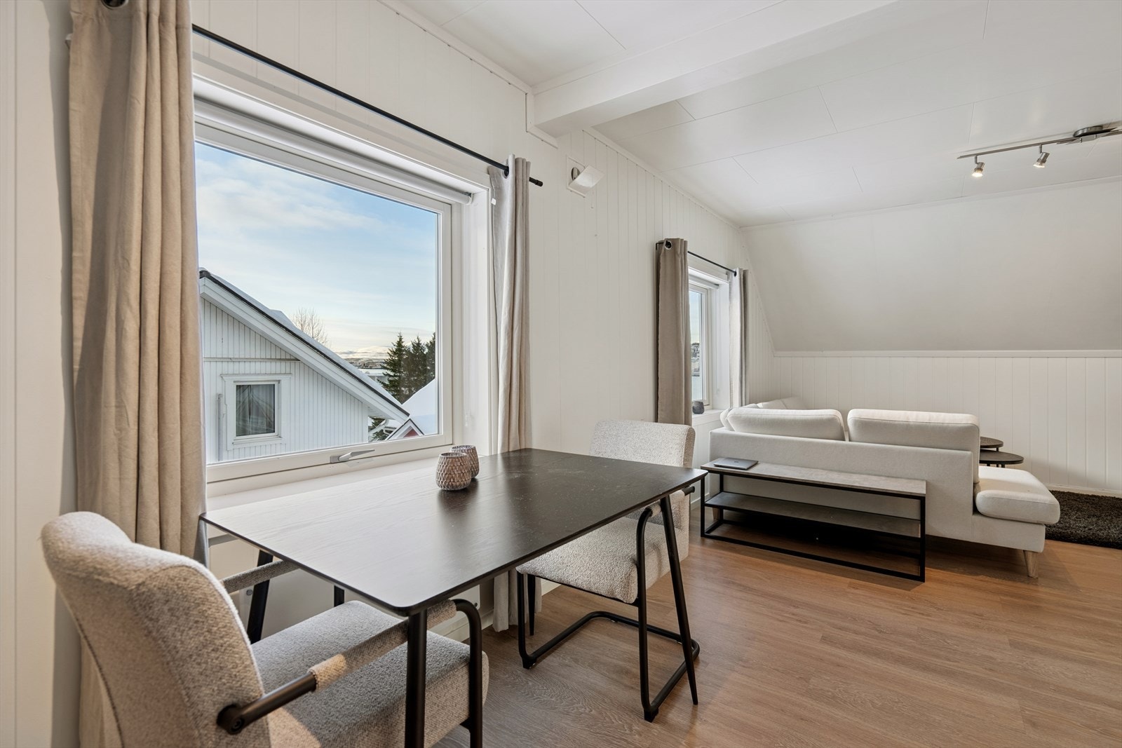 Leiligheten har en åpen stue- og kjøkkenløsning som gir plass til både sofagruppe og en spiseplass. Galleribilde