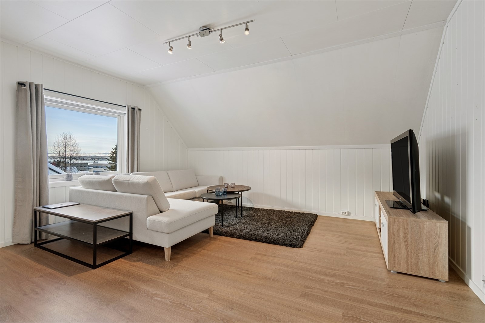 Sofagruppen/tv-kroken har en lys og trivelig plassering ved vinduet. Galleribilde